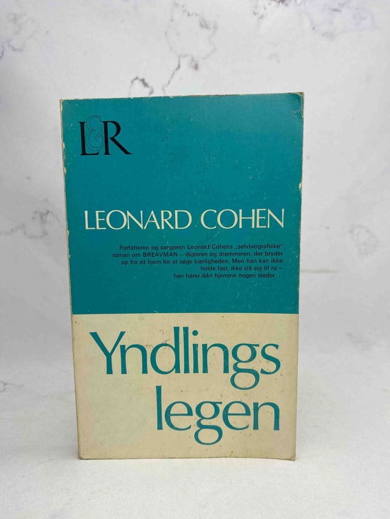 Cover for Leonard Cohen · Yndlingslegen (Sewn Spine Book) [1. wydanie] (2025)